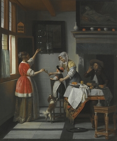 Interior with man drinking and two woman with a child feeding a parrot by Pieter de Hooch