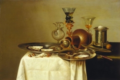 Still life of a laid table with perfume bottle by Cornelis Mahu