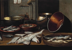 A kitchen interior with fish and utensils on a table by Floris van Schooten