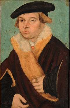 Portrait of a clean-shaven young man in a cloak trimmed with light fur by Lucas Cranach the Elder