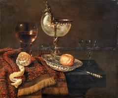 Still life with nautilus cup, salt cellar, roemer, façon de Venise glass and table carpet by Willem Claesz Heda