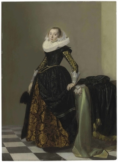 Portrait of a richly dressed young lady, full-length, before a draped table by Pieter Codde